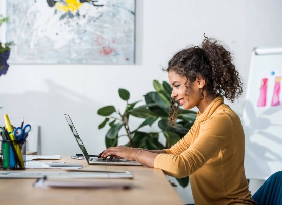 Google Ads Frau tippt Laptop lächeln 