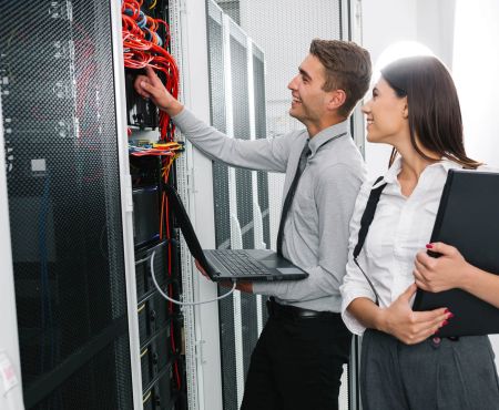 IT-Betreuung Mann Frau Server Laptop lächeln Kabel IT-Service